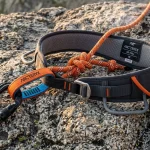 Imbragatura da arrampicata tecnica con anello di servizio, nodo a otto legato e moschettoni su roccia granitica