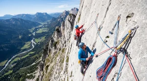 Arrampicatori su parete verticale con mezze corde rosse e blu in sosta durante una salita multipitch