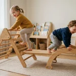 Bambini che giocano su una struttura in legno per arrampicata in cameretta
