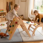Bambini che giocano in sicurezza su un triangolo di arrampicata in legno e materassini morbidi indoor