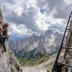 Confronto tra scalatore su roccia calcarea con corda dinamica e via ferrata con cavo dacciaio nelle Dolomiti